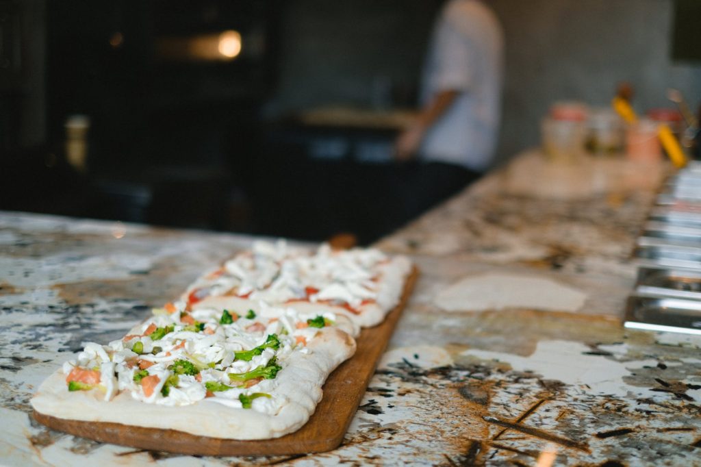 an uncooked pizza on a wooden board